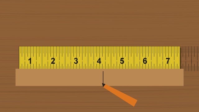 Tape measure stretched across shop material with a pencil mark and clear inch markings
